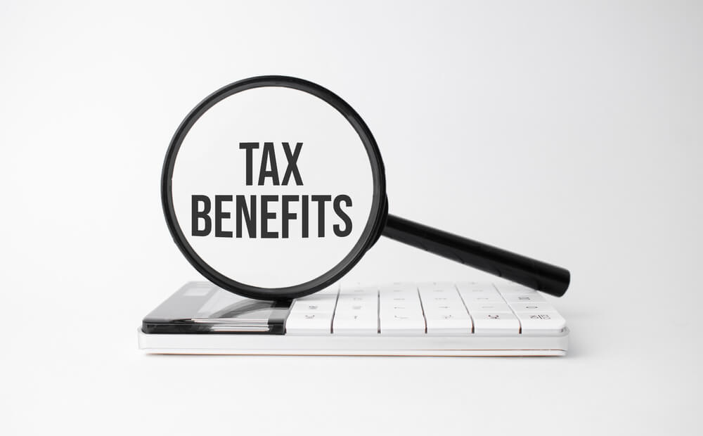 Tax benefits concept with magnifying glass on white background
